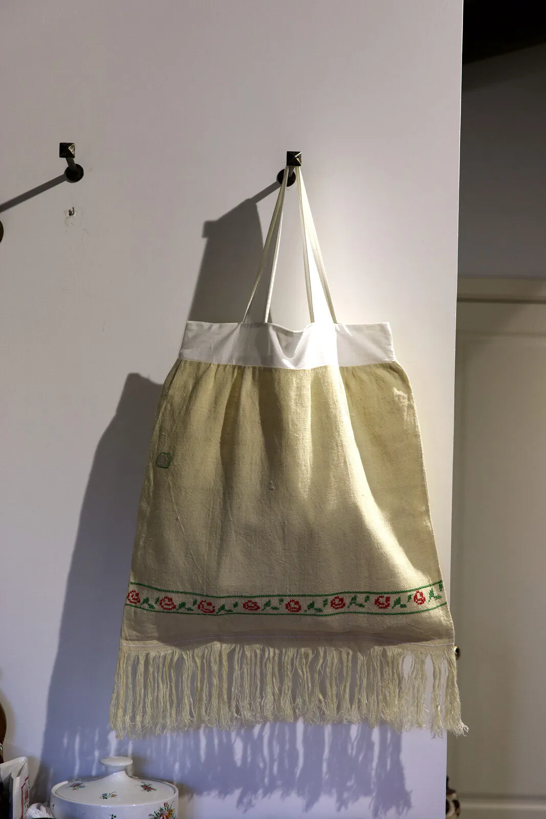 La shopper appesa a un gancio, con la fascia ricamata in vista